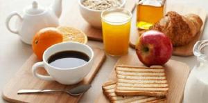 a breakfast table with a cup of coffee and breakfast foods at Hotel 65 in London