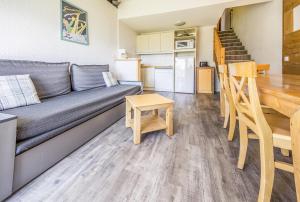 a living room with a couch and a table at Residence Le Pedrou - maeva Home in Font Romeu Odeillo Via