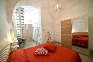 Un dormitorio con una cama con una colcha roja. en da Nonna Lata, en Martina Franca