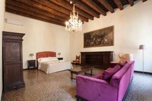 ein Wohnzimmer mit einem lila Sofa und einem Bett in der Unterkunft Palazzo Valmarana Braga in Vicenza