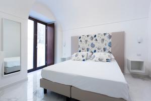 a white bedroom with a large bed and a window at Holiday Sorrento Center in Sorrento