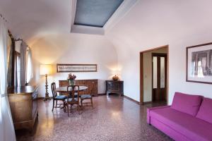 uma sala de estar com um sofá roxo e uma mesa em Palazzo Valmarana Braga em Vicenza