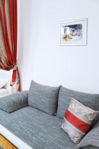 ein graues Sofa mit einem roten und weißen Kissen in der Unterkunft Modern Apartment Všehrdova in Prag