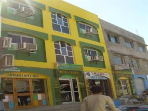 a man riding a bike in front of a building at Hotel Laabh in Diu