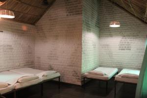 a room with three beds in a brick wall at Shannu's Ranch Inn in Pushkar