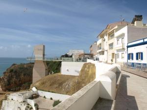 a large rock on the side of a building next to the ocean at Casa da Praia in Albufeira