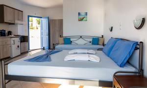 a large bed with blue pillows in a room at Iliovasilema VILLAGE in Donoussa