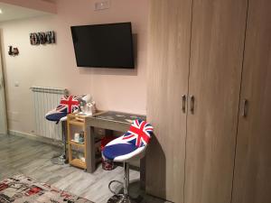a room with two bar stools with a desk and a television at B&B Cuore di Salerno in Salerno