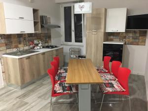 a kitchen with a wooden table and red chairs at B&B Cuore di Salerno in Salerno