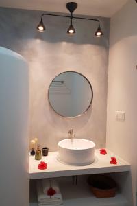 a bathroom with a white sink and a mirror at Coco Villa in Thoddoo