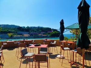 a patio area with tables, chairs and umbrellas at Vincci Porto in Porto
