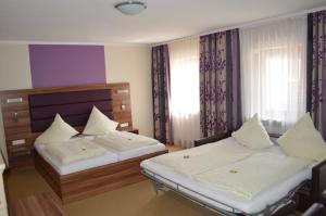 a bedroom with two beds and a window at Hotel Daimerwirt in Moosinning