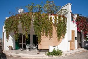 a white building with a patio with a bunch of flowers at B&B Villa Ines in Leuca