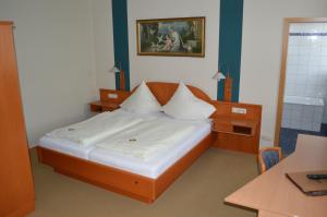 a small bedroom with a bed and a table at Hotel Daimerwirt in Moosinning