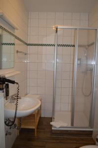 a bathroom with a shower and a sink at Hotel Daimerwirt in Moosinning