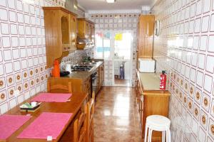 una cocina con armarios de madera y encimeras rosas en Turistic Home Velázquez, en Málaga