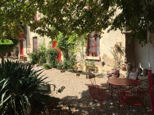 une terrasse avec une table et des chaises devant un bâtiment dans l'établissement Aux Caprices des Dieux, à Marnes