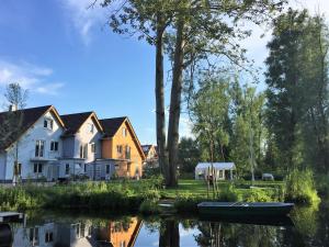 a house and a boat on the water next to a lake at KapLuv Plau am See in Plau am See