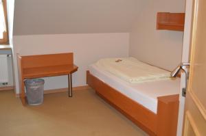 a small bedroom with a bed and a desk at Hotel Daimerwirt in Moosinning