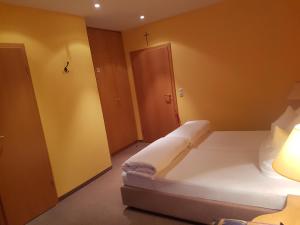 um quarto com uma cama branca e uma parede amarela em Gasthof Krapp em Litzendorf
