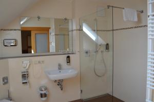 a bathroom with a sink and a shower at Hotel Daimerwirt in Moosinning