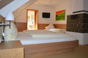 a bedroom with two beds and a tv on the wall at Hotel Daimerwirt in Moosinning