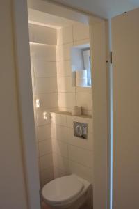 a small bathroom with a toilet and a mirror at Ferienwohnung am Meer in Scharbeutz