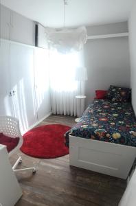 a bedroom with a bed and a red rug at Getxo, parking, wifi, metro in Getxo