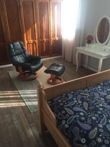 a bedroom with a bed and a chair and a mirror at Getxo, parking, wifi, metro in Getxo