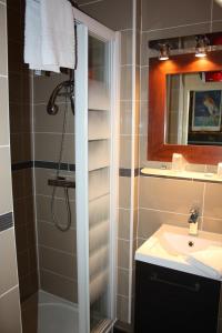 La salle de bains est pourvue d'une douche et d'un lavabo. dans l'établissement Hôtel République, à Dijon