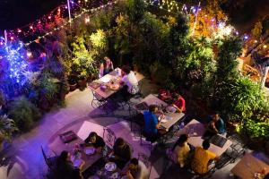 a group of people sitting at tables in a garden at night at Hotel Kalyan in Jaipur
