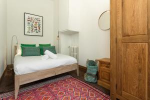 a bedroom with a bed with green pillows and a rug at Apartment Majestic 1 in Chamonix
