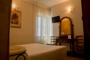um quarto com uma cama, uma secretária e uma janela em Locanda dell'Arcangelo em Rocca Massima