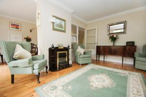 a living room with two chairs and a fireplace at Dean Court Bungalow - Parking - by Brighton Holiday Lets in Rottingdean