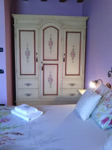a bedroom with a large white bed with pink walls at Le Cocche in Affi