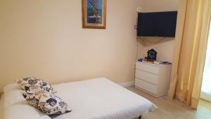 a small room with a bed and a flat screen tv at Dépendance La Casetta in Castellammare di Stabia