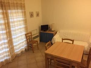 ムルタ・マリアにあるCasa Vacanza a Porto Istanaのベッド、テーブル、椅子が備わる小さな客室です。