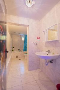 een badkamer met een wastafel, een douche en een bad bij Pirate Backpackers in Ulcinj