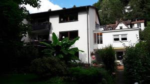 ein weißes Haus mit Bäumen davor in der Unterkunft Ferienwohnung Neckarblick in Heidelberg