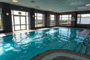 a large swimming pool with a person in the water at The Golden Jubilee Hotel in Clydebank