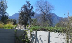 a white fence with mountains in the background at Apartment in Heather Park in George