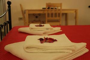 Guesthouse Casetta Verde في Novaki Motovunski: طاولة حمراء عليها مناشف بيضاء