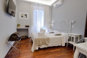 ローマにあるボルゲーゼ エグゼクティブ スイートの白いベッドルーム(ベッド1台、テーブル付)
