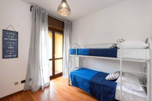 une chambre avec trois lits superposés et une fenêtre dans l'établissement Ortaglia A2, à Torri del Benaco