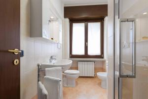 une salle de bain avec un lavabo et des toilettes et une fenêtre dans l'établissement Ortaglia A2, à Torri del Benaco