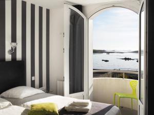 a bedroom with a bed and a view of the ocean at Le Castel Ac'h in Plouguerneau