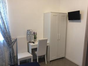 Dieses kleine Zimmer verfügt über einen Schreibtisch und einen weißen Schrank. in der Unterkunft Aquarius Rome in Mostacciano 
