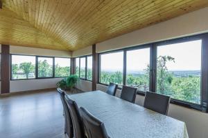 a conference room with a table and chairs and windows at Conacul lui Bulică in Novaci-Străini