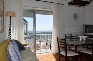 a living room with a table and a large window at Casa de Zira in Nazaré