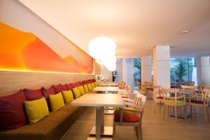 restauracja z drewnianymi stołami i kolorowymi krzesłami w obiekcie Cala D Or Apartamentos w mieście Puerto Rico de Gran Canaria